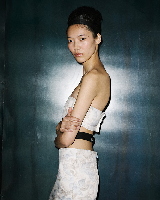 Max Mara Spring/Summer 2026 Fashion Show - Backstage shot of model with Look with white Bandeau Top and matching Skirt.
